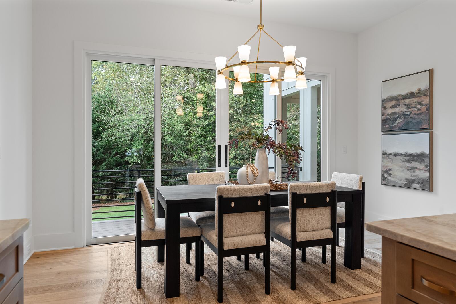 A dining room with flat, cleanly finished walls and ceiling beside a glazed door