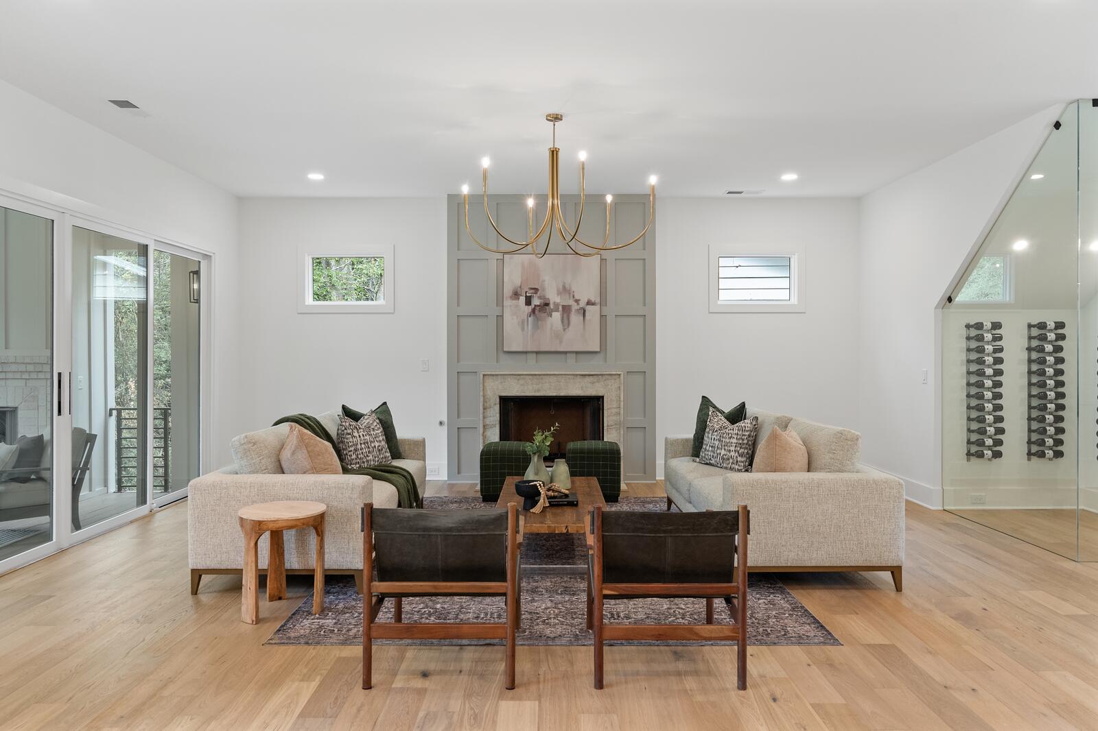 A living room with wide-plank hardwood running through to the fireplace